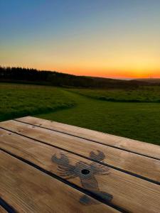 a wooden bench with a daisy painted on it at Pentire Coastal Holiday Park in Bude