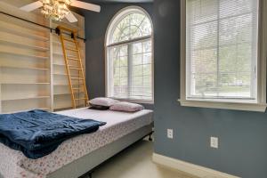a bedroom with a bed and a ladder and two windows at Lancaster Vacation Rental Near Dutch Wonderland! in Lancaster