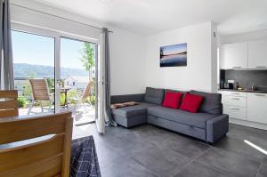 een woonkamer met een grijze bank en rode kussens bij Ferienwohnung Maier in Bodman-Ludwigshafen