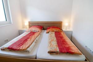 twee bedden met kussens in een slaapkamer bij Ferienwohnung Maier in Bodman-Ludwigshafen