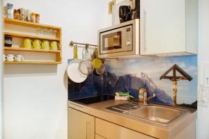 eine Küche mit einer Spüle und einer Mikrowelle in der Unterkunft Berghex in Garmisch-Partenkirchen