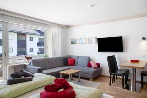 ein Wohnzimmer mit einem Sofa und einem TV in der Unterkunft Berghex in Garmisch-Partenkirchen