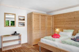 1 dormitorio con 2 camas y pared de madera en Berghex, en Garmisch-Partenkirchen