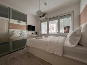 - une chambre avec un lit blanc et une fenêtre dans l'établissement Pearl Center - 2BDR, à Bucarest