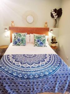 een bed met een blauwe en witte deken en kussens bij Exclusivo Apartamento a 500 metros de la Playa in Castelldefels