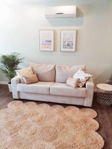 un divano bianco in soggiorno con tappeto di Exclusivo Apartamento a 500 metros de la Playa a Castelldefels