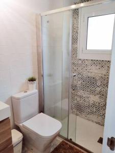 e bagno con servizi igienici e doccia in vetro. di Exclusivo Apartamento a 500 metros de la Playa a Castelldefels
