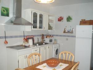 cocina con mesa, fregadero y nevera en Casa Rural El Hollejo, en Pulgar