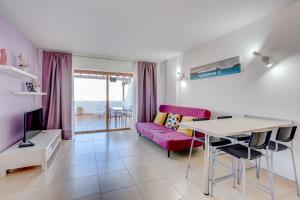 a living room with a pink couch and a table at Parque Royal 1A255 in Adeje