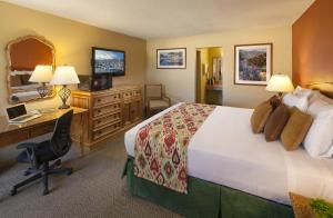 a hotel room with a bed and a desk at Sandpiper Lodge - Santa Barbara in Santa Barbara