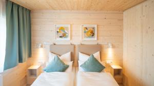 ein Schlafzimmer mit zwei Betten mit blauen und weißen Kissen in der Unterkunft freilich. Bistro. Bar. Hotel - digitaler self check in in Laa an der Thaya