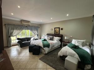 - une grande chambre avec 2 lits et un canapé dans l'établissement ARK Guesthouse, à Potchefstroom