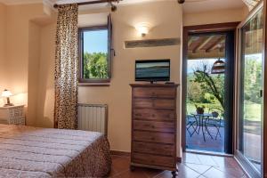 una camera con letto, televisore e finestra di Villa Poggio Di Gaville a Meleto