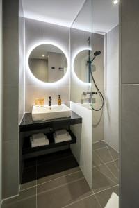 ein Bad mit einem Waschbecken und einem Spiegel in der Unterkunft LOGINN Hotel Waiblingen in Waiblingen