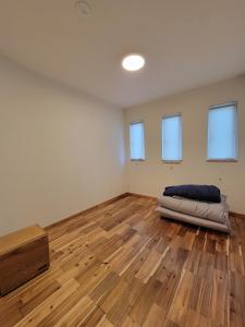 泊まる寿司屋一力 Sushi house في Itoshima: غرفة فارغة مع سرير على أرضية خشبية
