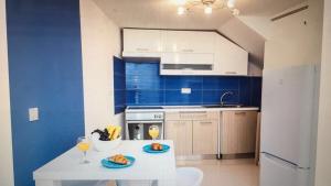 a kitchen with blue walls and a table with glasses of wine at Apartment 7 in Bol