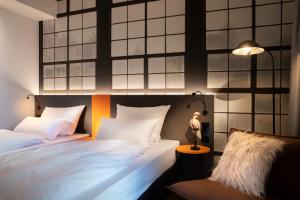1 dormitorio con 2 camas y lámpara en LOGINN Hotel Waiblingen, en Waiblingen