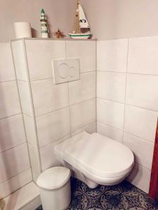 małą białą łazienkę z toaletą i umywalką w obiekcie Ferienwohnung Baade -KEINE MONTEURE- w mieście Friedrichskoog-Spitz