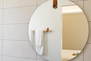 a mirror in a bathroom with white tiles at La VIA Rooms and Terrace in Olbia