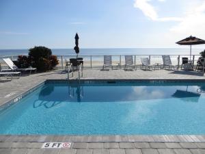 a swimming pool with a view of the beach at Lotus Boutique Inn and Suites in Ormond Beach