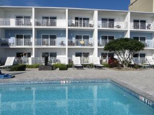 a hotel with a swimming pool in front of a building at Lotus Boutique Inn and Suites in Ormond Beach