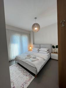 a white bedroom with a large bed with white sheets at Mozart House - Spacious Luxury Apartment - Heart of the City in Tirana