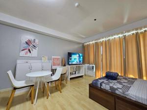 - une chambre avec un lit, une table et des chaises dans l'établissement N place at Soho Central, à Manille