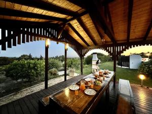 una mesa de madera con comida en la cubierta en Tavira Vila Formosa 3 With Pool by Homing en Tavira