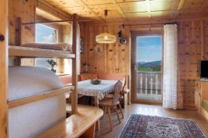1 Schlafzimmer mit Etagenbetten, einem Tisch und einem Balkon in der Unterkunft Apartment Rosengartenblick 