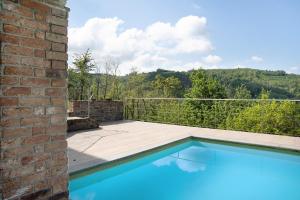 uma piscina numa casa com uma parede de tijolos em La Corte di Langa alloggio Rubino em Albaretto Della Torre 