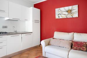 sala de estar con sofá y pared roja en La Corte di Langa alloggio Rubino, en Albaretto Della Torre 