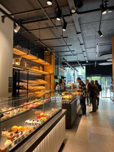a bakery with people standing in front of a display case at Mozart House - Spacious Luxury Apartment - Heart of the City in Tirana