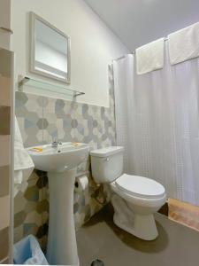 a bathroom with a white toilet and a sink at Hostal Solari in Trujillo