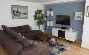 a living room with a couch and a flat screen tv at Tgesa Sunnmatt Nr 46 in Savognin