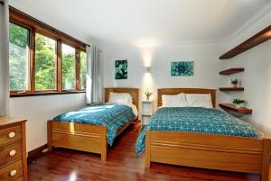 a bedroom with two beds and two windows at Chalets Alpins- 10 Chemin des Montagnards in Stoneham