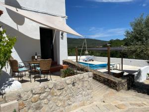 a patio with a table and chairs and a pool at Casa Pollard in Marvão
