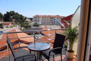 a balcony with a table and chairs on a roof at Rooms and Apartments Robert in Rovinj