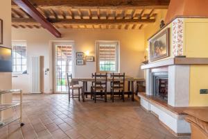 sala de estar con mesa y chimenea en Italian Experience-Glicine Holiday Apartment, en Castello Ripalta