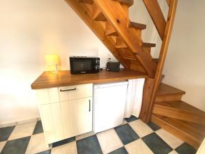 a kitchen with a microwave on a counter under a staircase at Casuca El Trisquel - 18002 in Bareyo +24 photos