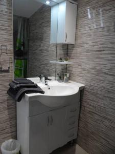 bagno con lavandino bianco e specchio di Chalet Canne à Sucre a Saint-André