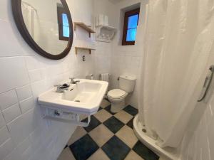 a bathroom with a sink and a toilet and a mirror at Casuca El Trisquel - 18002 in Bareyo