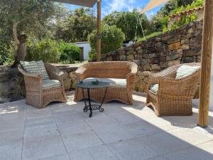 trzy wiklinowe krzesła i stół na patio w obiekcie Casa Pollard w mieście Marvão
