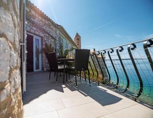 a balcony with a table and chairs overlooking the ocean at Apartment Julietta in Rab +16 photos