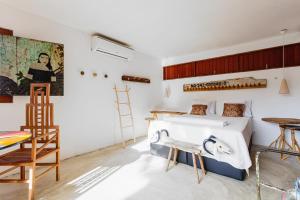 a bedroom with a bed and a desk and a chair at Toca do Frei - Ilha do Ferro in Pão de Açúcar +9 photos