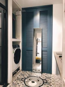 a kitchen with a blue door and a mirror at Sweetheart in Saigon in Ho Chi Minh City