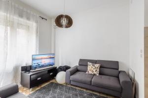 ein Wohnzimmer mit einem Sofa und einem Flachbild-TV in der Unterkunft Mestre Altamarea Apartment in Mestre