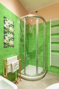 a bathroom with a shower with green tiles at Malpensa Garden in Case Nuove