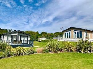 a house with a green lawn in front of it at Pentire Coastal Holiday Park in Bude