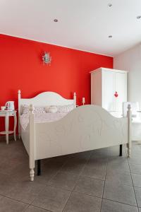 a bedroom with a white bed and red walls at Malpensa Garden in Case Nuove