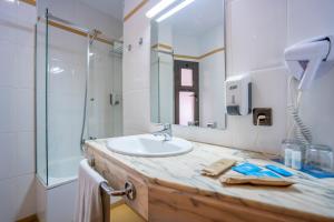a bathroom with a sink and a shower and a mirror at YIT Conquista de Toledo in Toledo